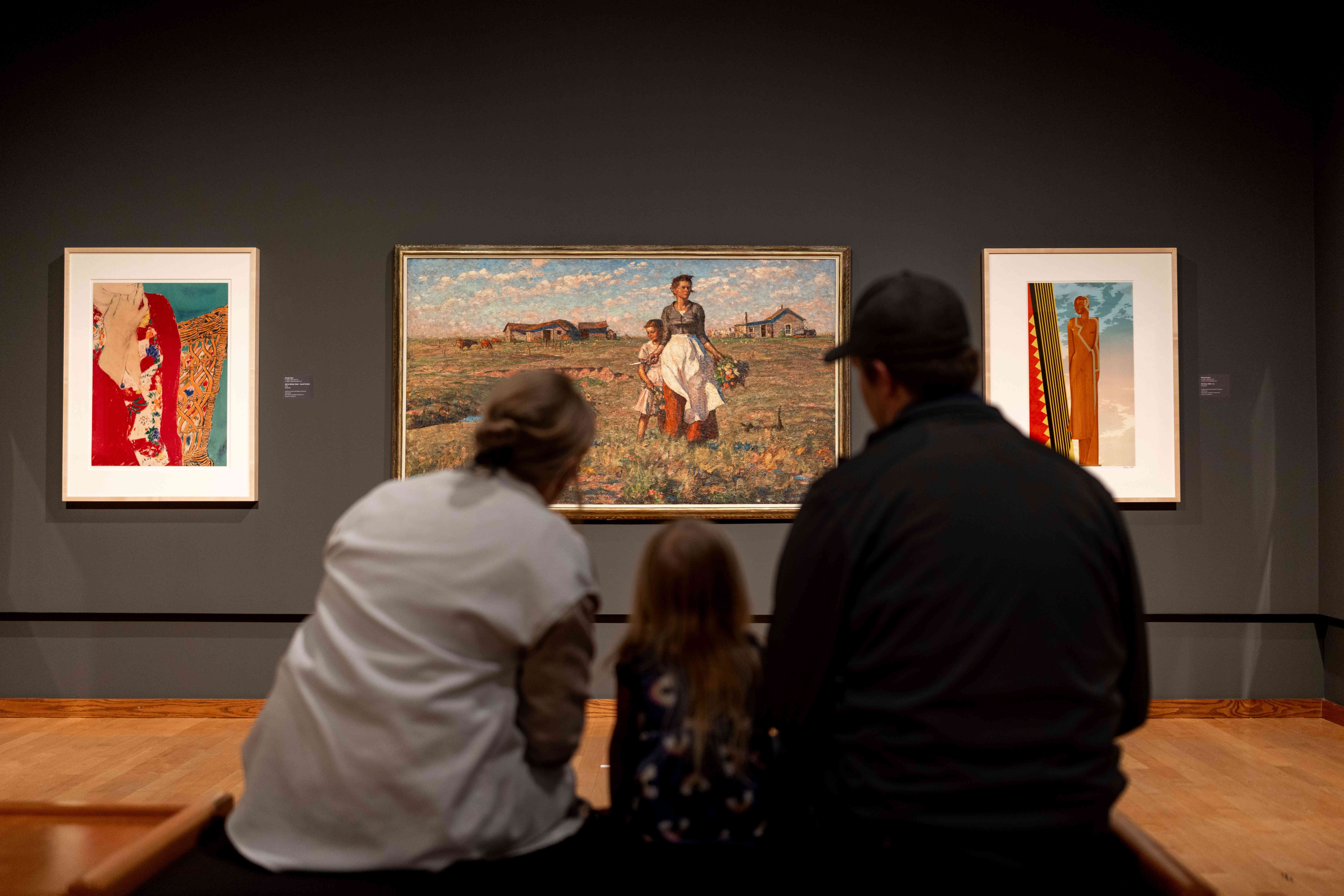 Family looking at three paintings at the South Dakota Art Museum in Brookings