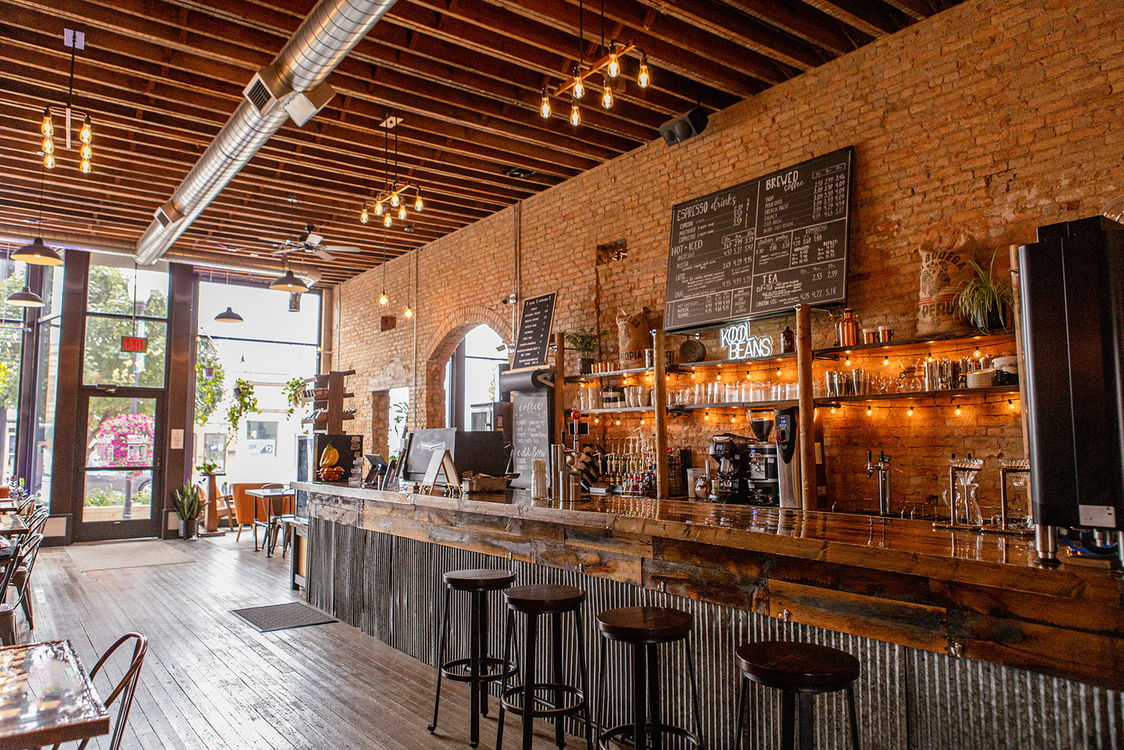 An overview of the bar at Kool Beans Coffee and Roasterie with historic brick and warm atmosphere.