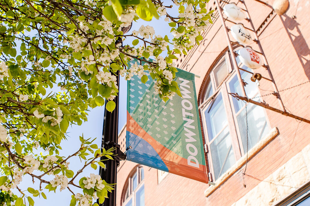 exterior of Kool Beans featuring historic signage, green leaves and a Downtown Brookings banner.