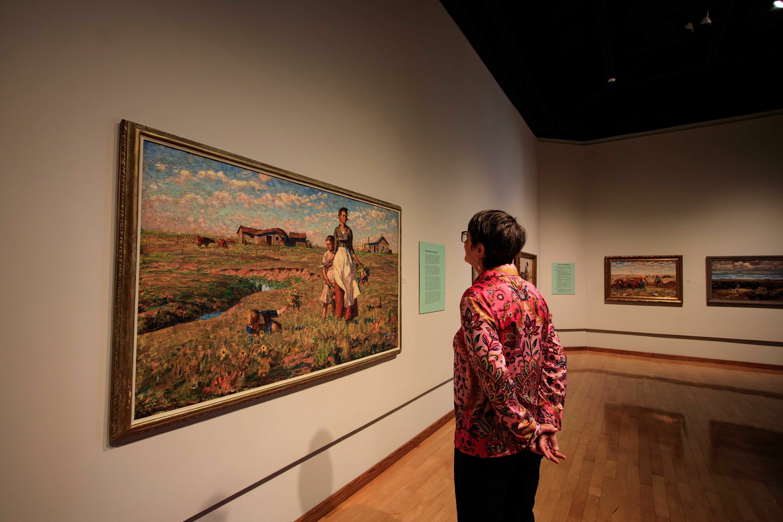 A female guest admiring Harvey Dunn's The Prairie is My Garden.