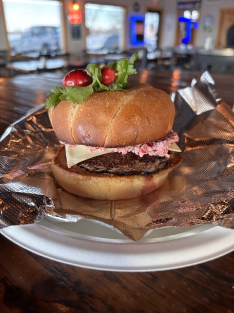 A burger with a cranberry sauce topped with two cranberries