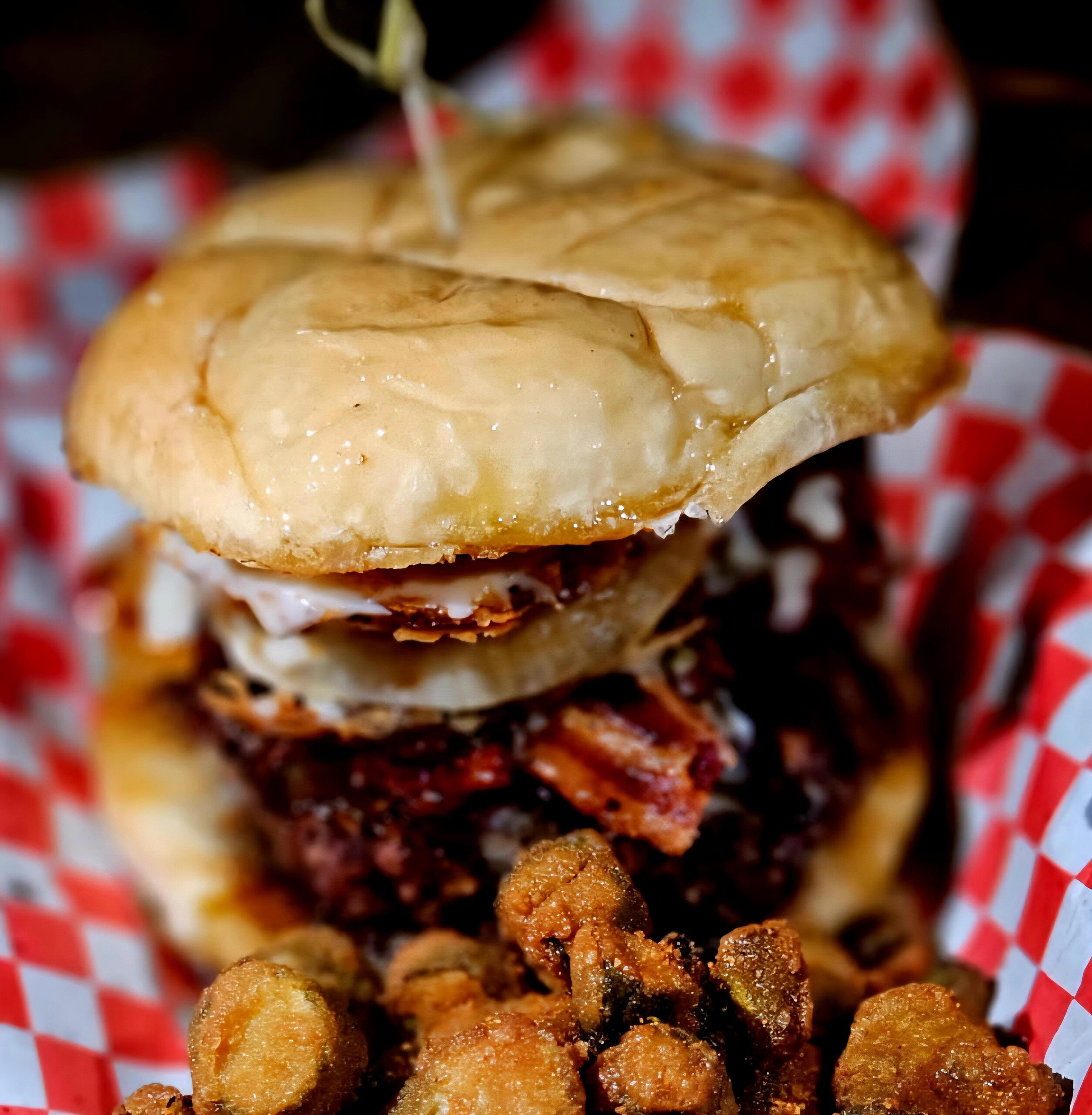 A burger with lots of toping and queso