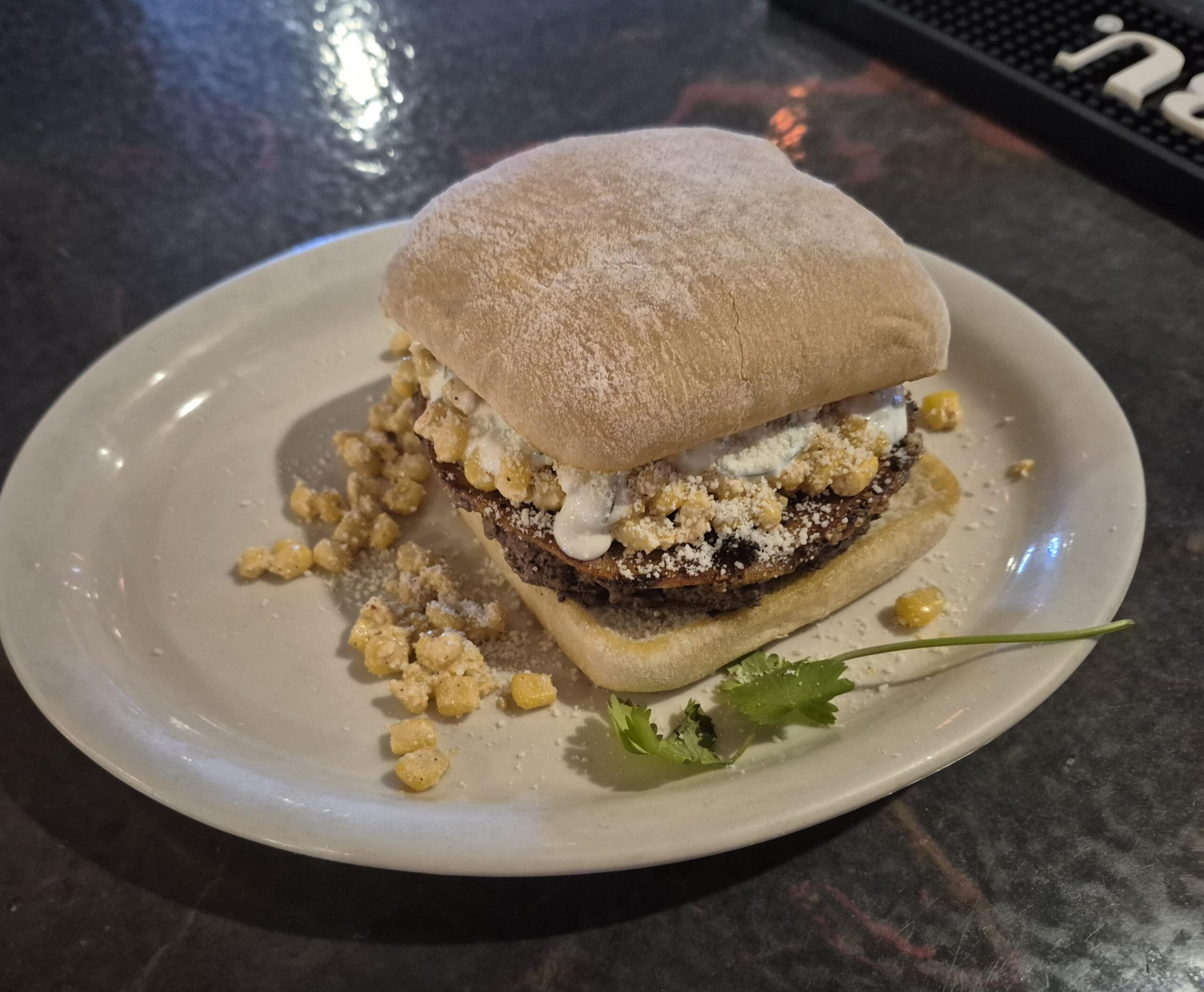 A burger with corn salsa served on square bun