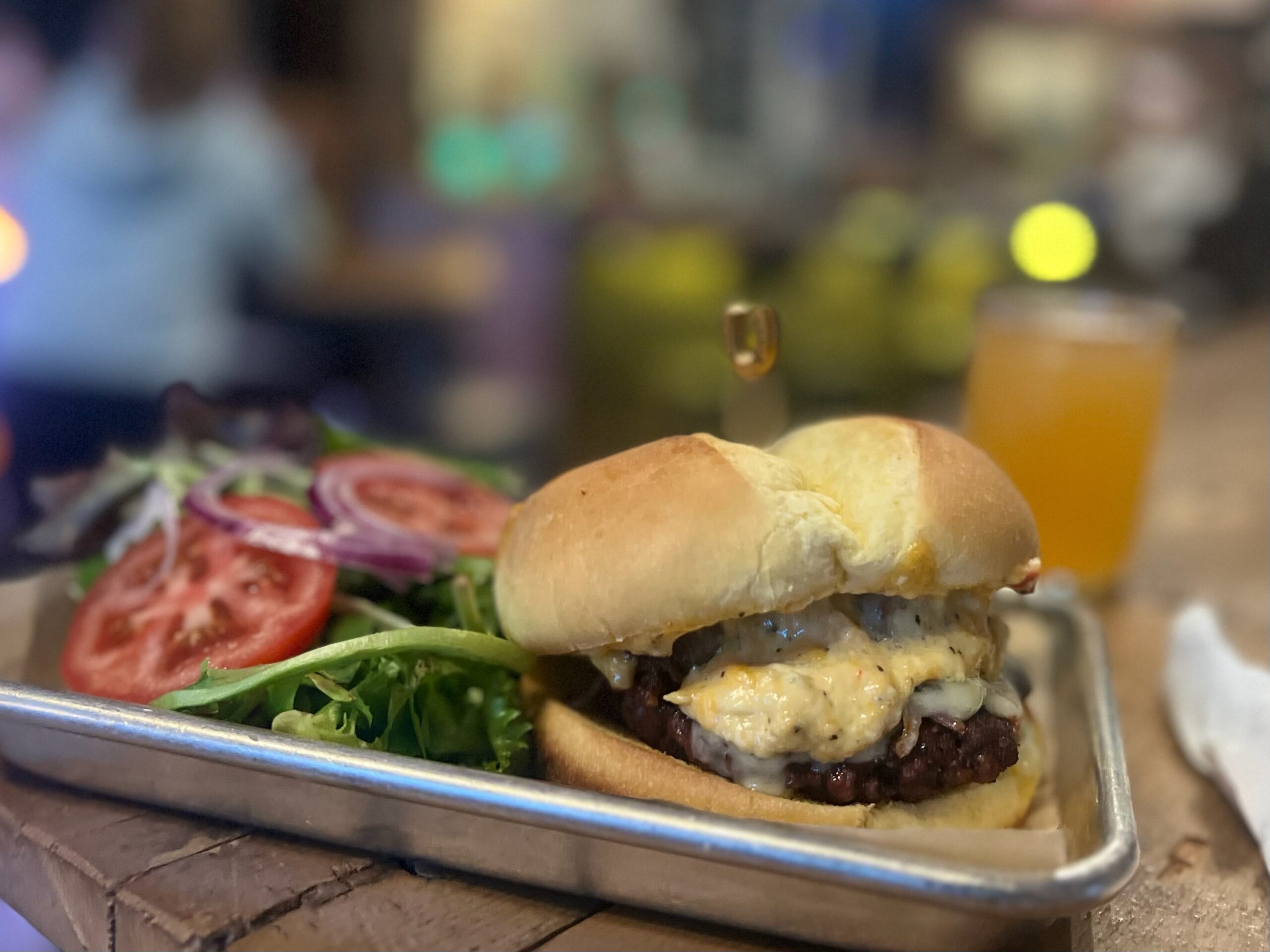 Burger with cheese sauce with greens on the side