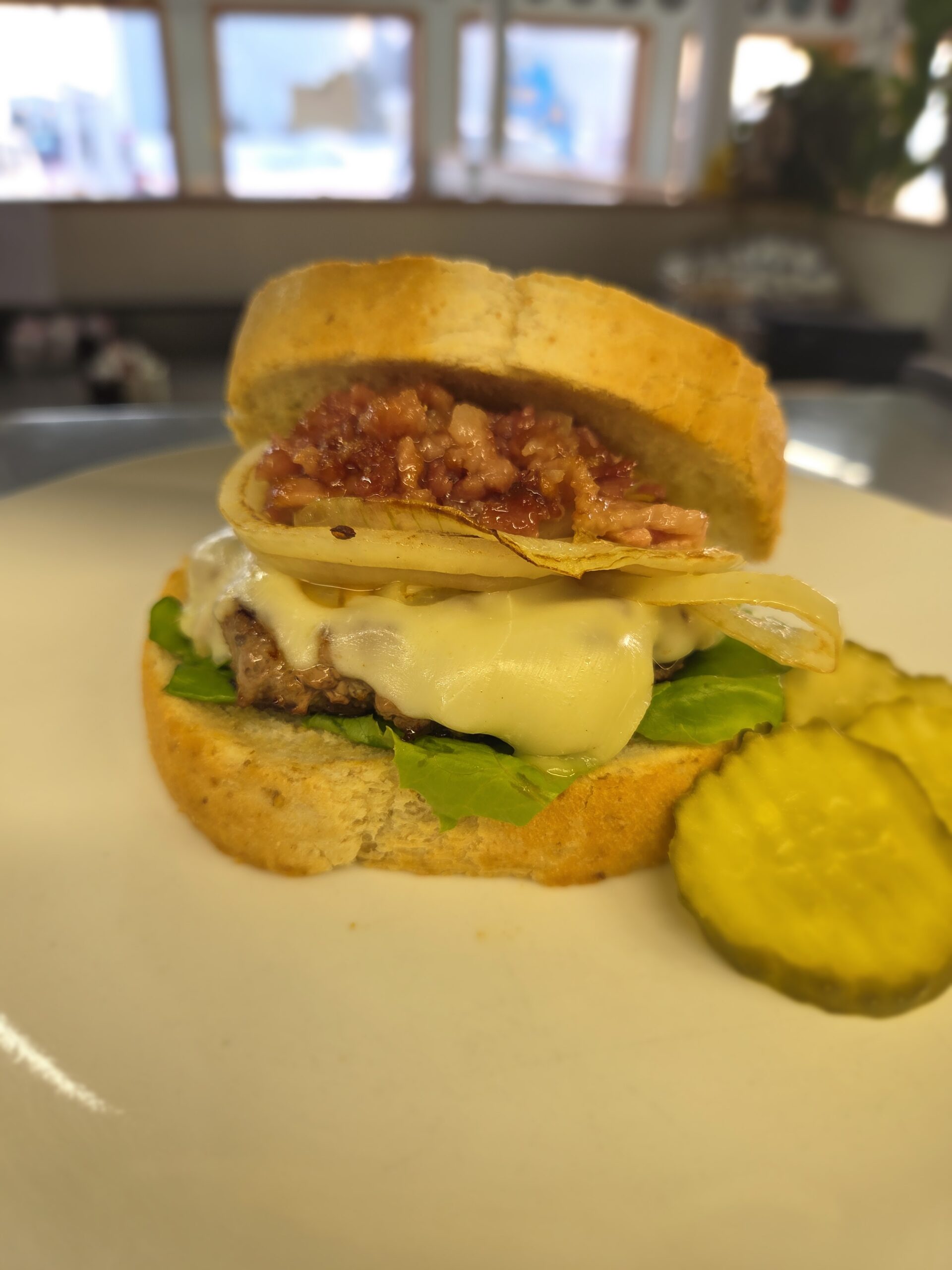 Burger with cheese and grilled onions served on top of toasted sourdough